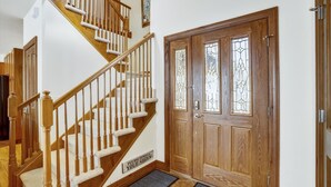 A wooden staircase with a handrail, a double door with glass panels, and a 'Please remove your shoes' sign. - Breck Townhome, Hot Tub, Great Views, Seasonal Shuttle, Sleeps 10 (Breckenridge)