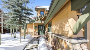 A snow-covered pathway leading to a building with stone walls and wooden siding. - Breck Townhome, Hot Tub, Great Views, Seasonal Shuttle, Sleeps 10 (Breckenridge)