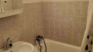 Ein Badezimmer mit Waschbecken, Spiegel und Badewanne.