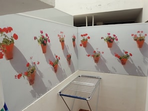 Un balcón con plantas en macetas y un tendedero.