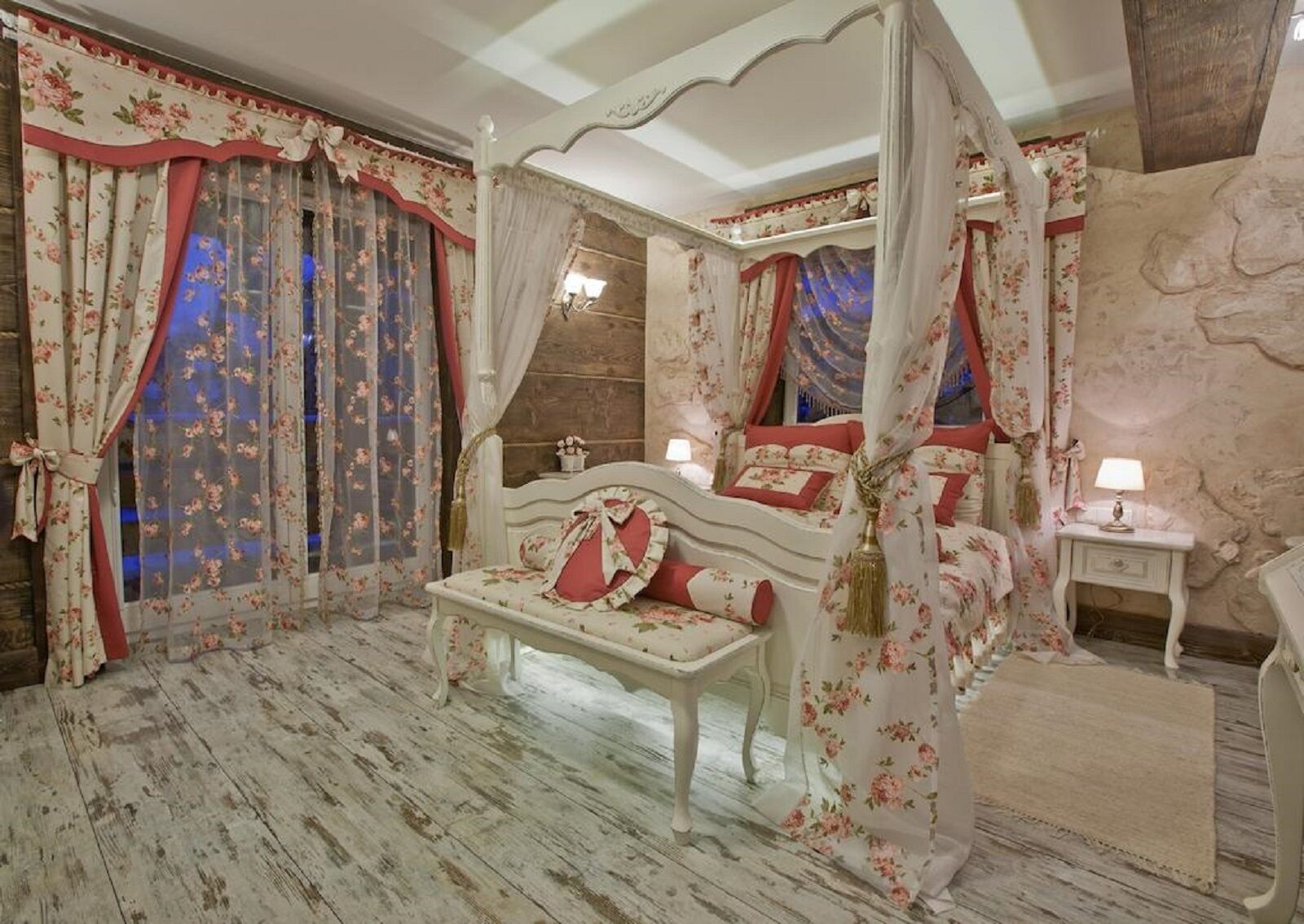 A four-poster canopy bed with floral curtains and a wooden floor.