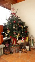 Árvore de Natal decorada com enfeites, uma estrela e um boneco de gengibre.