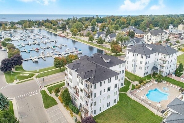 A residential area with a marina, modern apartment buildings, and a swimming pool.