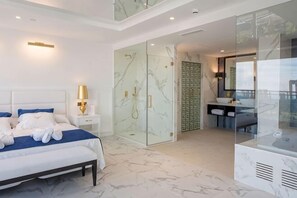 A modern bedroom with a bed, bedside table, and a glass-enclosed shower area. - Four Points by Sheraton Costa Blanca Resort (Benidorm)