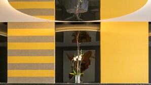 A dining area with a round table, two chairs, and a vase with flowers. - Four Points by Sheraton Costa Blanca Resort (Benidorm)
