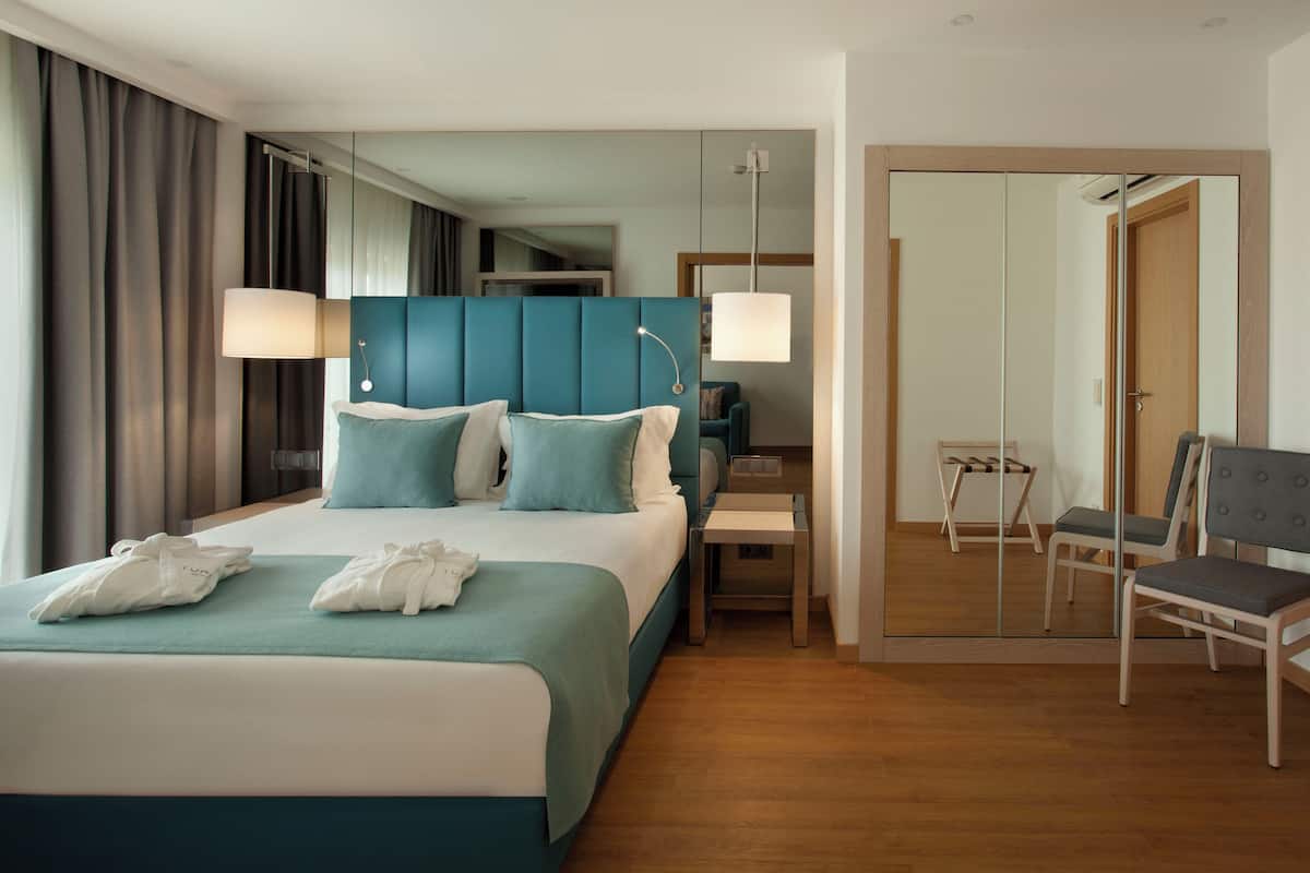 Quarto de hotel moderno com uma cama grande, uma mesa e uma cadeira.