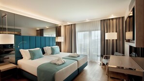 Een moderne hotelkamer met een groot bed, een bureau en een televisie.
