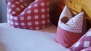 A bed with a checkered pillow and a polka-dotted pillow.