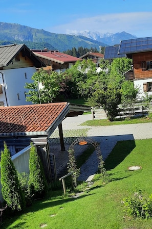 Um bairro residencial com casas, um caminho pavimentado e montanhas ao fundo.