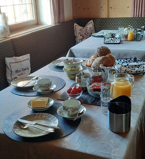 Uma mesa posta com pratos, talheres e diversos alimentos para o café da manhã.