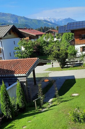 Um bairro residencial com casas, um caminho pavimentado e montanhas ao fundo.