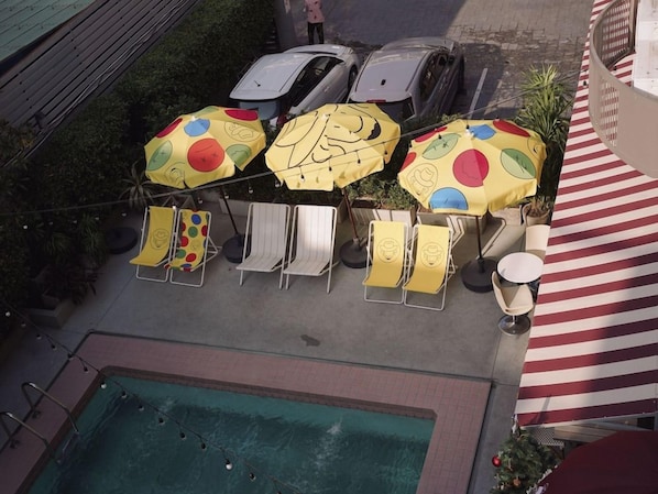 A poolside area with lounge chairs, umbrellas, and a pool. - Josh Hotel (Bangkok)