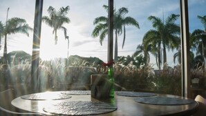 A round table with placemats, a green bottle, and a menu stand. - Ribalta Hotel Barra da Tijuca by Atlantica (Rio de Janeiro)