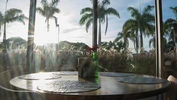 A round table with placemats, a green bottle, and a menu stand.