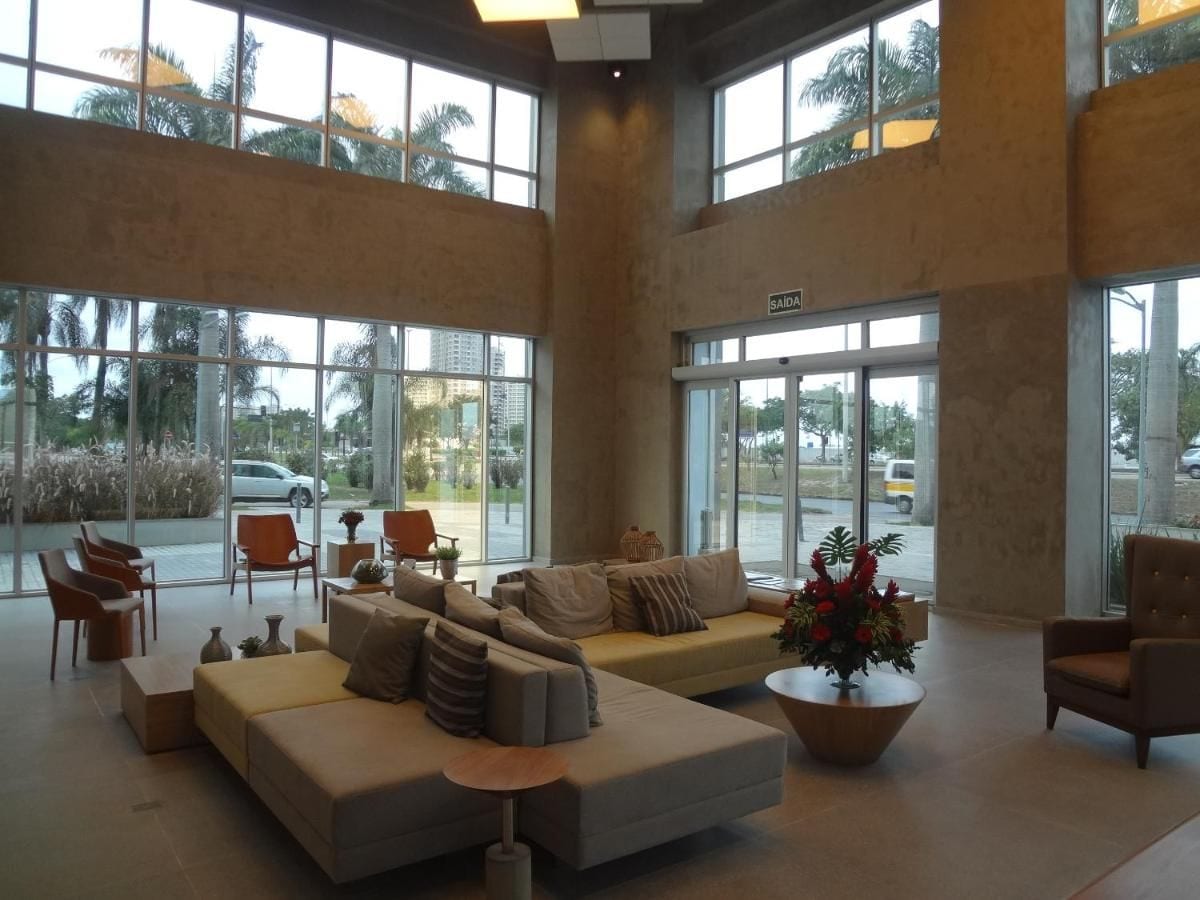 A spacious lobby with a large seating area, including sofas and chairs, and large windows offering a view of the outside.