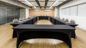 A conference room with a long table, chairs, and a brick wall. - Ribalta Hotel Barra da Tijuca by Atlantica (Rio de Janeiro)