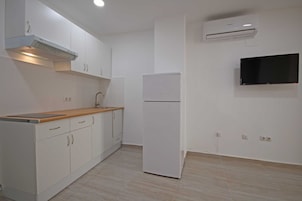 Frigorífico pequeño, placa de cocina y utensilios de cocina