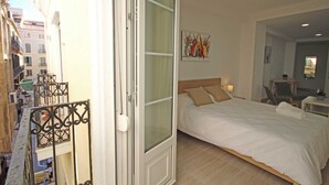 Una camera d'albergo con un letto, un quadro, una scrivania e una sedia.