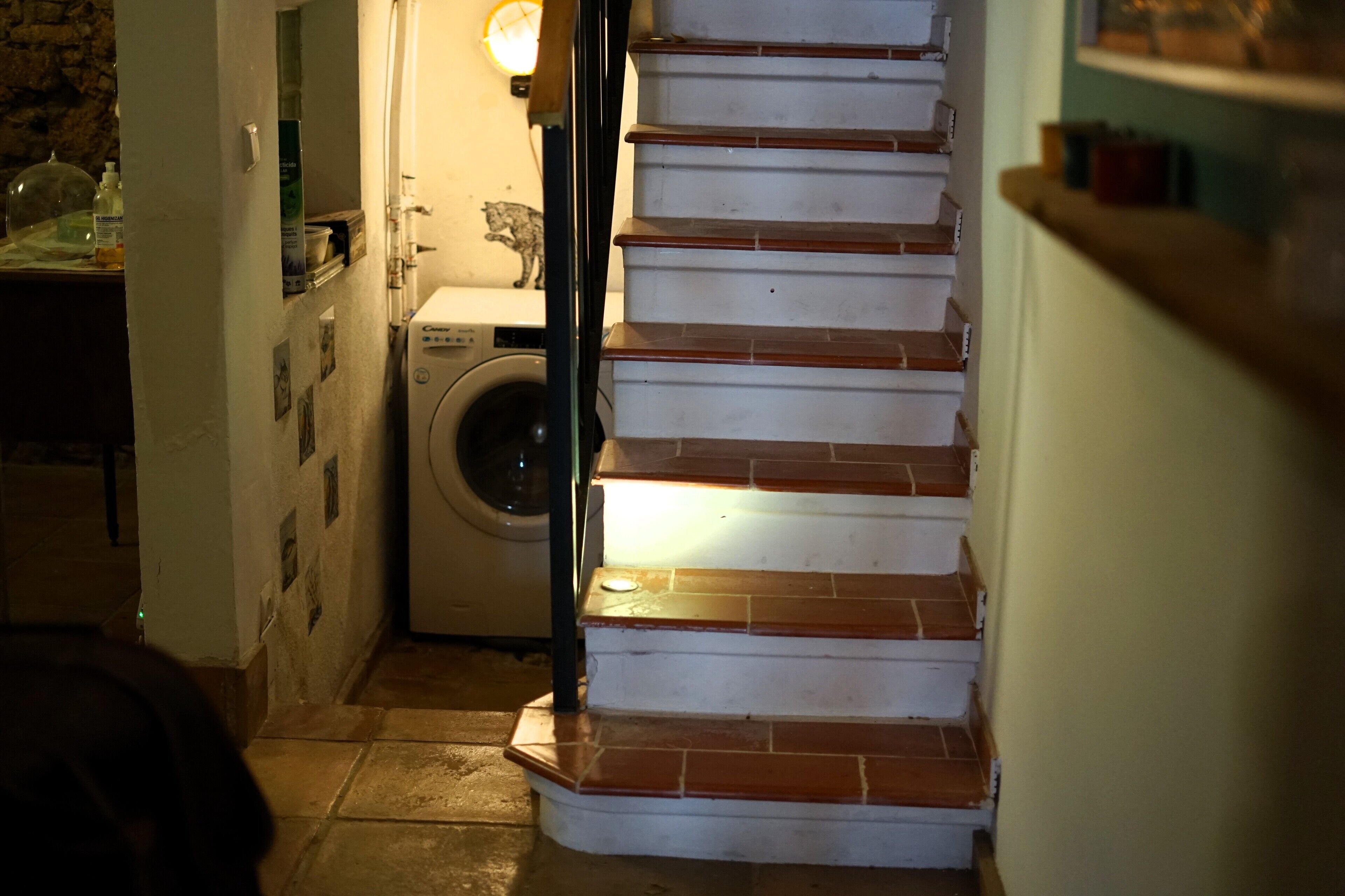 A staircase with a handrail and a light fixture above it.