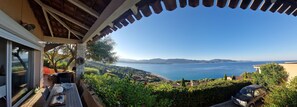 A terrace with a view of the sea, a table with chairs, and a car parked nearby. - THE BALCONIES OF VALINCO La Vigie No. 5 (Olmeto)