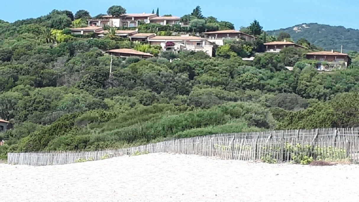 Una colina con casas y una valla de madera.
