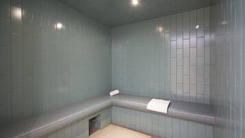 Bathroom features a tiled floor and walls with a bench for resting.