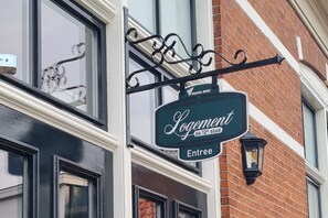 A building with a sign that reads "Logement de 12e étage Entree" and "PANTA RHEI". - Logement de 12e Stad - Private studio in former school near Leeuwarden (Berlikum)
