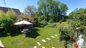 A well-maintained garden with a lawn, a table and chairs under a canopy, and a variety of plants and trees. - Cozy gite 3 *, 2 to 4 people, 1st floor in the house. Individual entrance. (67370 Berstett)