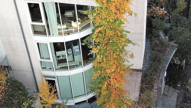 A modern multi-story building with large windows and a flat roof.