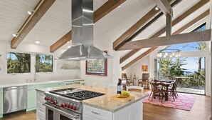A spacious kitchen with a large island, stainless steel appliances, and a view to the outdoors. - Pebble Beach's Empire (Pebble Beach)