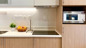 Una cocina moderna con un microondas Bosch, un lavabo y una cesta de frutas sobre la encimera.