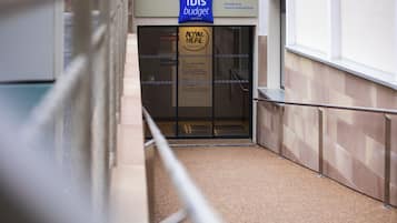 A hotel entrance with a sign for 'Ibis Budget' and a 'Planet 21' sign.