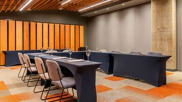 A conference room with a long table, chairs, and a projector.