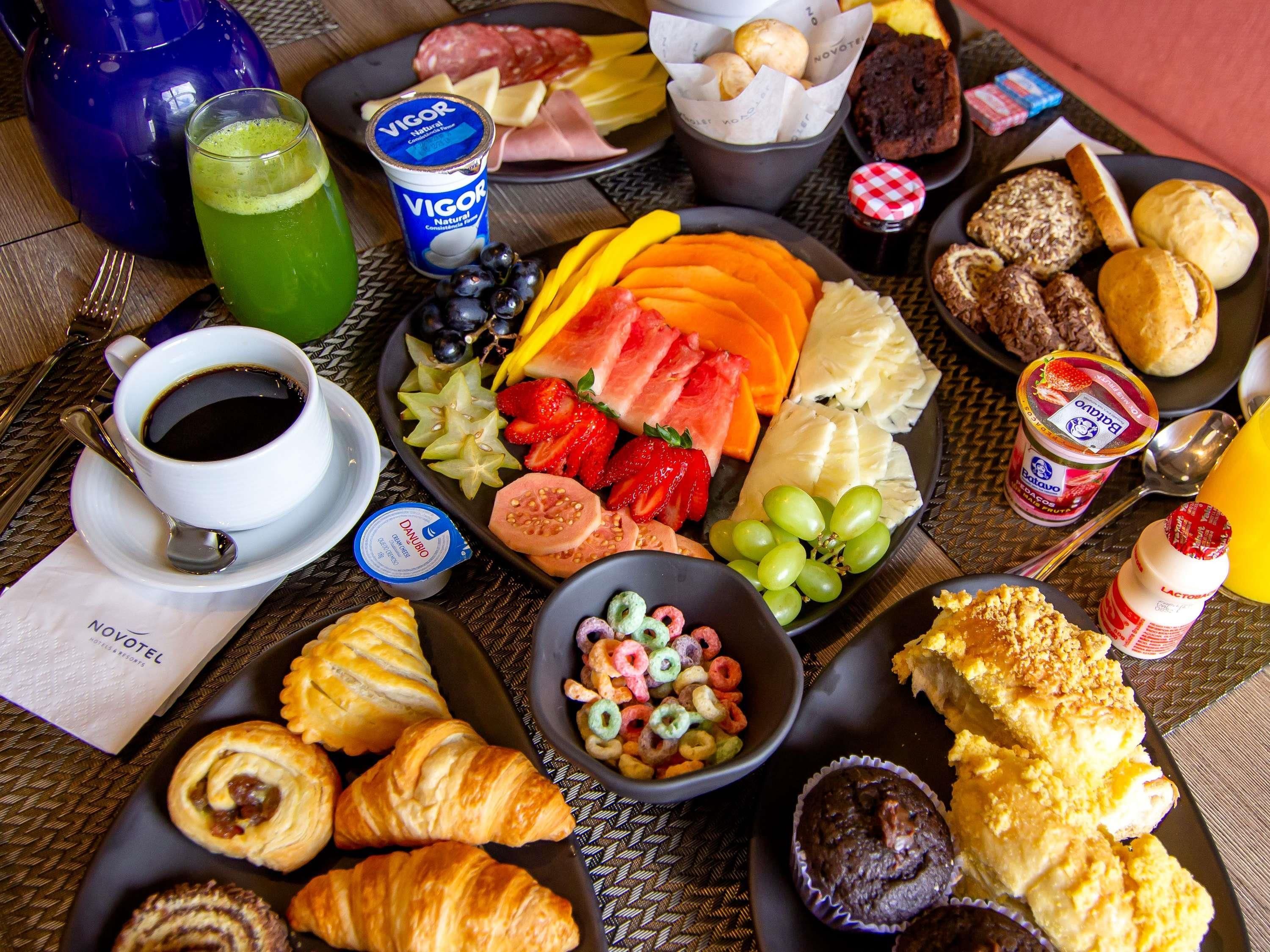 A breakfast buffet with various food items, including pastries, fruits, and beverages.