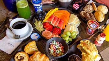 A breakfast buffet with various food items, including pastries, fruits, and beverages.