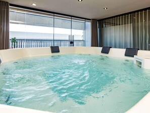 A hot tub with a view of a building through large windows. - Novotel Criciuma (Criciuma)