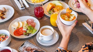 Una mesa de desayuno con platos de comida, una taza de café y un vaso de jugo.