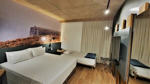 A hotel room with two beds, a large mural on the wall, a ceiling light, and a TV on the wall. - Novotel Criciuma (Criciuma)