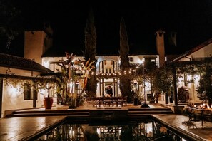 Ein Innenhof mit Pool, umgeben von Gebäuden mit großen Fenstern und Außenbereichen zum Sitzen.