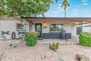 A house with a brick exterior, a front porch with a bench, and a cactus garden. - Sunset @ ASU | Pool, BBQ,  Game Room Near Campus (Tempe)