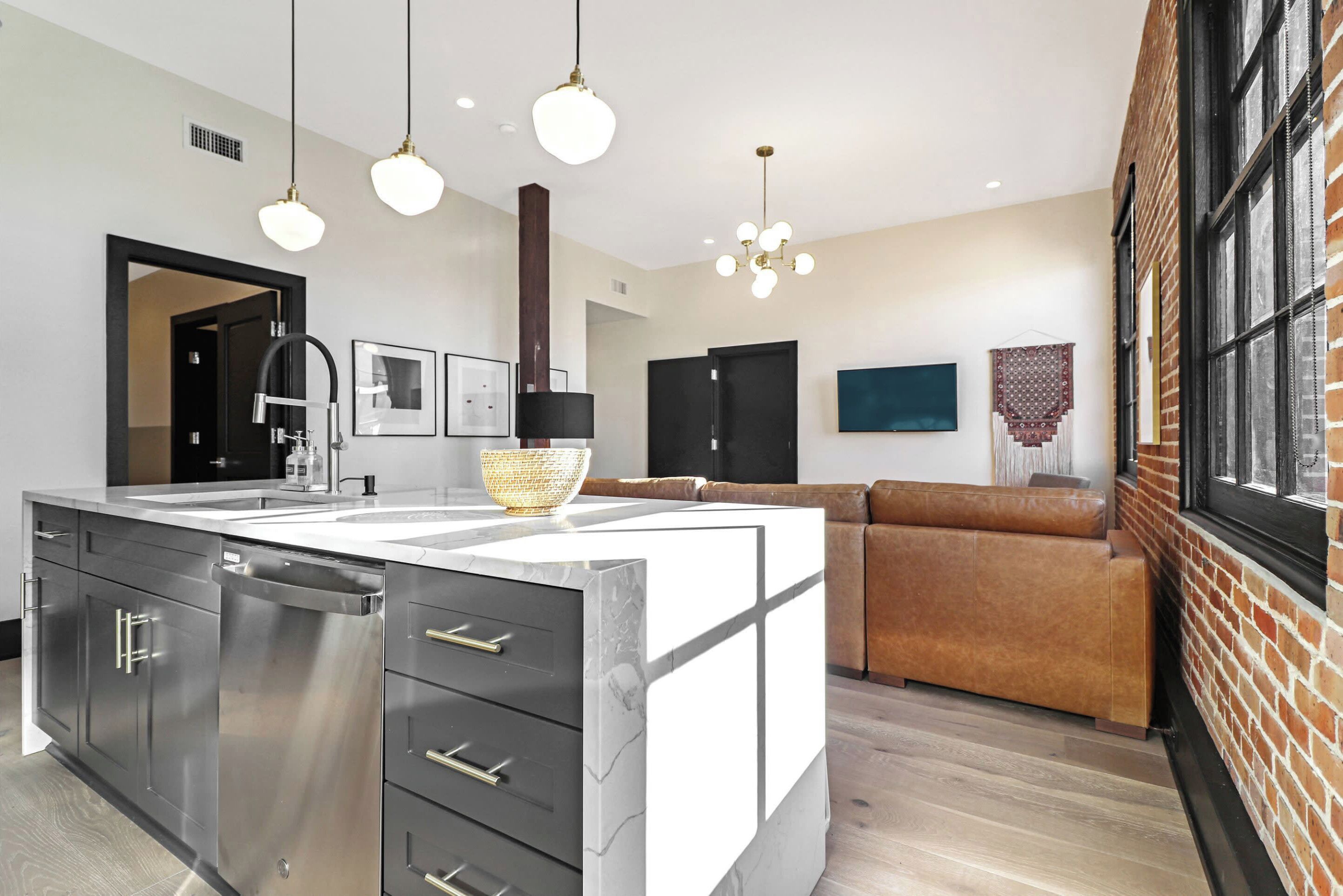 A modern kitchen with a central island, stainless steel appliances, and pendant lighting.