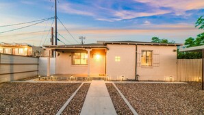 Une maison à deux étages avec une allée en gravier et un chemin menant à la porte d’entrée.