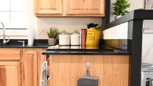 A kitchen with wooden cabinets, a black countertop, and a hanging oven mitt. - *Just off River Trail, Bikes, Fire Pit, Hot Tub* (Kerrville)
