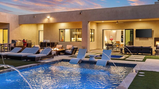 A pool area with lounge chairs, a barbecue grill, and a dining area with a view of the pool. - Sleek Paradise Valley Escape with Resort Pool and Indoor Outdoor Flow (Paradise Valley)