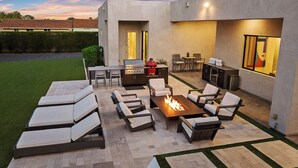 An outdoor patio with a grill, seating, and a fire pit. - Sleek Paradise Valley Escape with Resort Pool and Indoor Outdoor Flow (Paradise Valley)