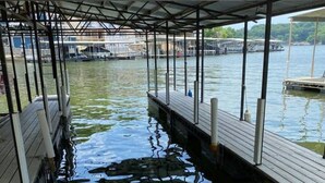 A covered dock area with a wooden walkway leading to a body of water. - Waterfront Cottage & Dock w/ Beautiful View - 5MM (Rocky Mount)