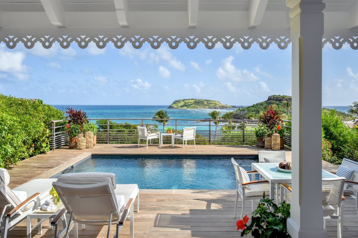 A pool area with a view of the ocean and a distant island.