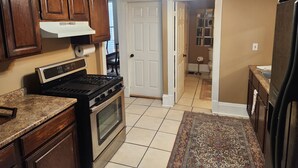 A kitchen with wooden cabinets, a stove, and a refrigerator.