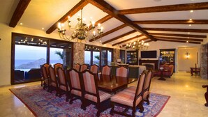 A spacious dining area with a large table and chairs, a chandelier, and a view of the ocean. - Luxury Pacific View Villa, Cabo San Lucas Villa 1005 (Cabo San Lucas)