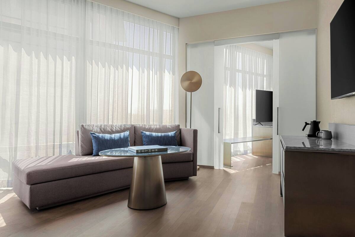 A modern living room with a sofa, a coffee table, and a floor lamp.